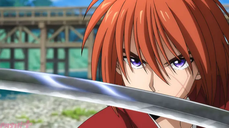 Kenshin Himura glares intensely over the glowing edge of his drawn reverse-blade sword in Rurouni Kenshin.