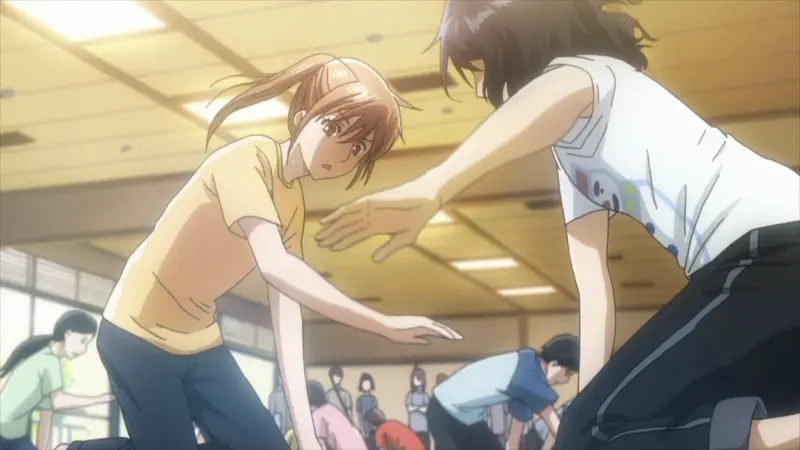 Chihaya Ayase and Shinobu Wakamiya reach for a karuta card on the tatami mat with intense focus during their competitive matchup.