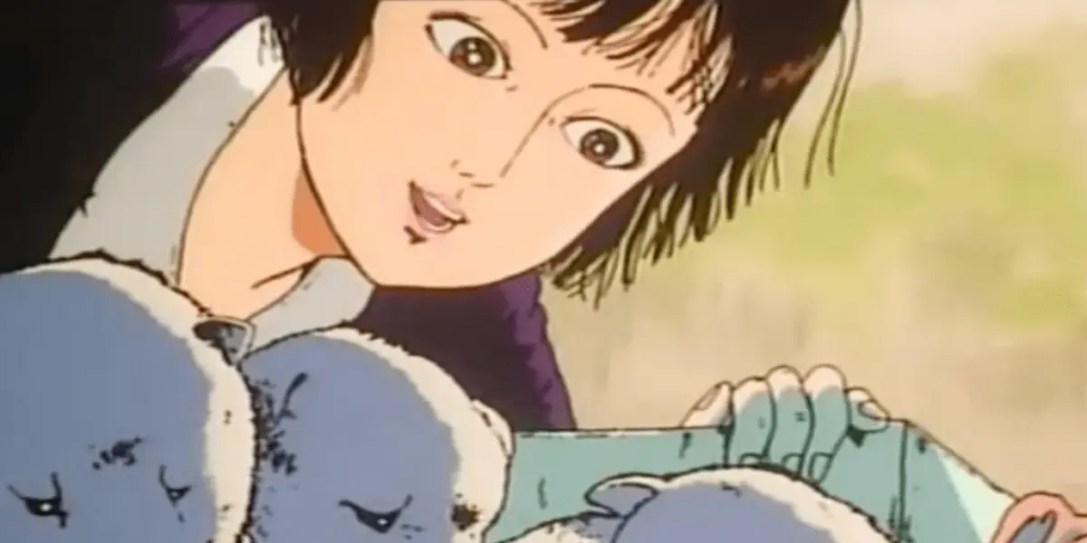 Midori looks down gently at a group of puppies in the controversial anime film Midori: Shoujo Tsubaki.