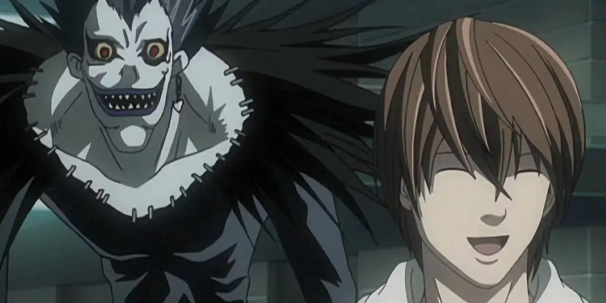 The Shinigami Ryuk stands menacingly behind a smiling Light Yagami in the anime Death Note.