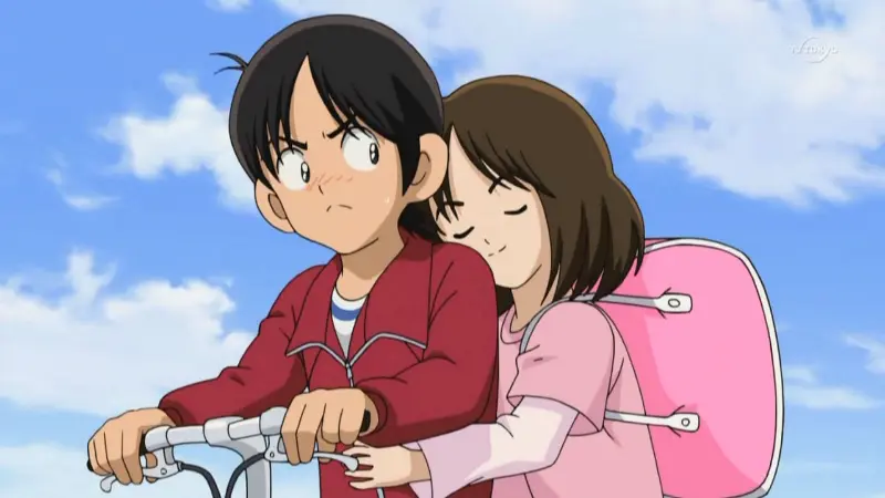 Aoba riding on the back of Ko's bicycle under a blue sky in the baseball anime Cross Game.