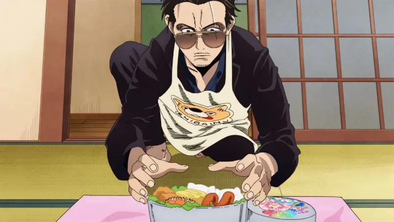 The former yakuza Tatsu wears sunglasses and a Shiba Inu apron while intensely presenting a carefully crafted bento box in The Way of the Househusband.