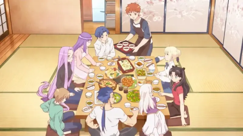 Shirou Emiya serving bowls of food to Saber, Rin, and other characters gathered around a large traditional Japanese dining table.