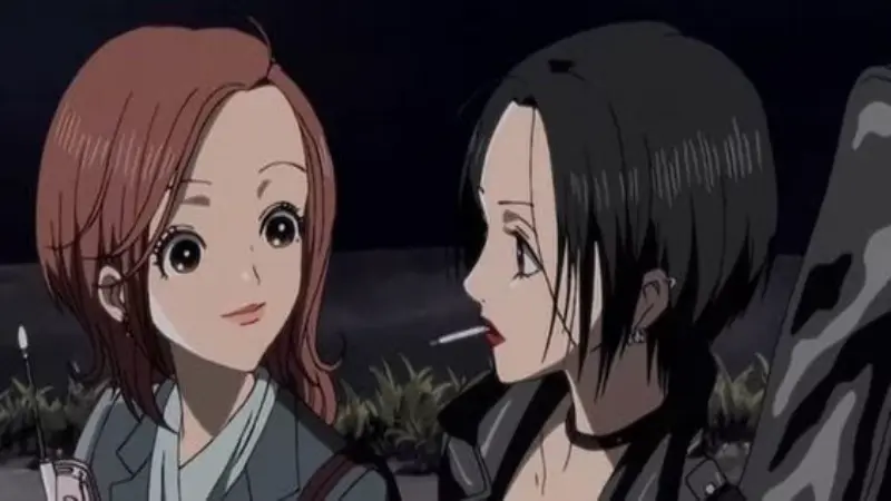 Nana Osaki smoking a cigarette while looking affectionately at Nana Komatsu during a late-night conversation outdoors.