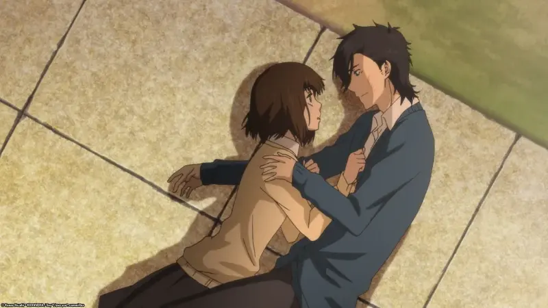 Yamato Kurosawa gently leans over Mei Tachibana as she lies on the ground outside.