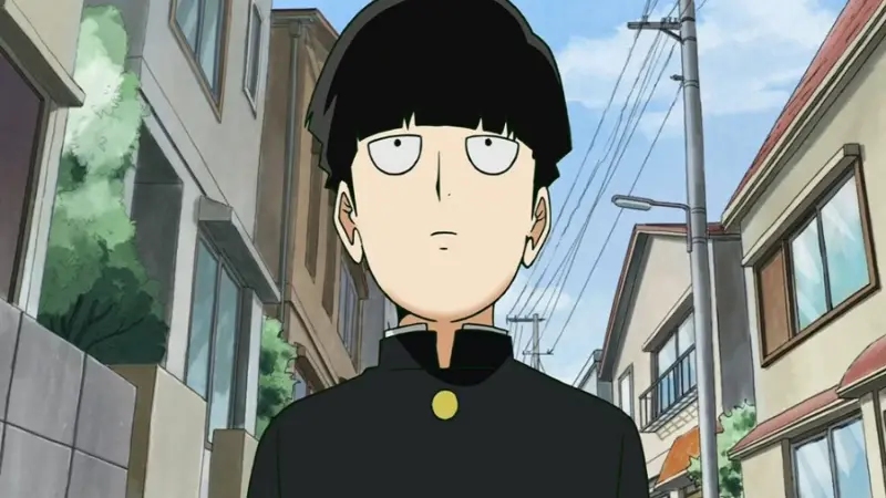 The overpowered psychic Shigeo Kageyama, also known as Mob, stands blankly on a suburban street in the no isekai anime Mob Psycho 100.