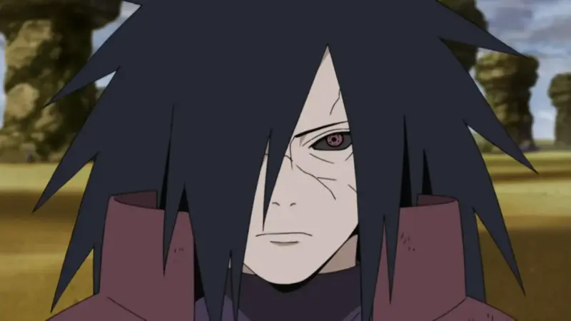 Madara Uchiha glares intensely with a single visible Sharingan eye, wearing his traditional deep red battle armor in Naruto.