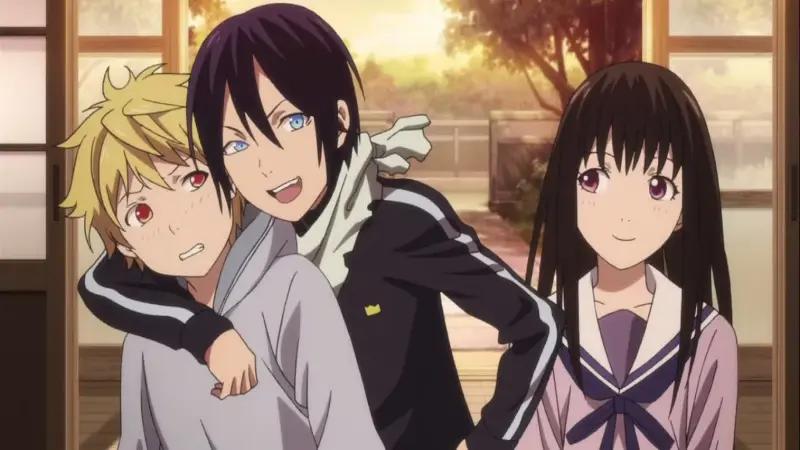 Yato smiling happily while holding Yukine in a headlock beside Hiyori in Noragami.