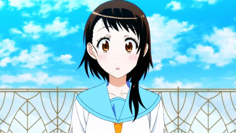 Nisekoi character Kosaki Onodera looking surprised in her school uniform against a bright blue sky.