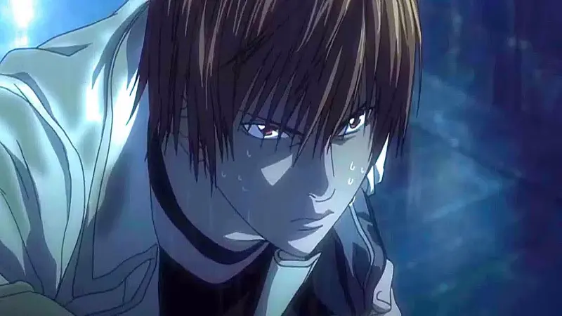 Light Yagami looks down with a dark, calculating glare while standing outside in heavy rainfall in the anime Death Note.